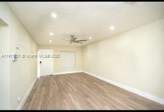 a view of a big room with wooden floor and windows