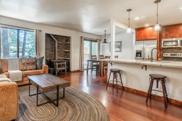 a living room with furniture a wooden floor and a large window
