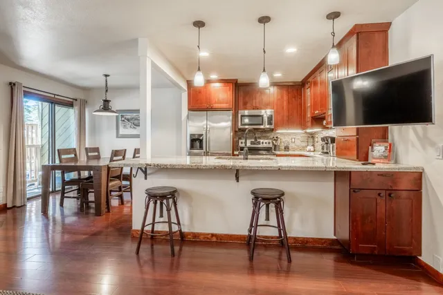a kitchen with a table chairs refrigerator microwave and cabinets
