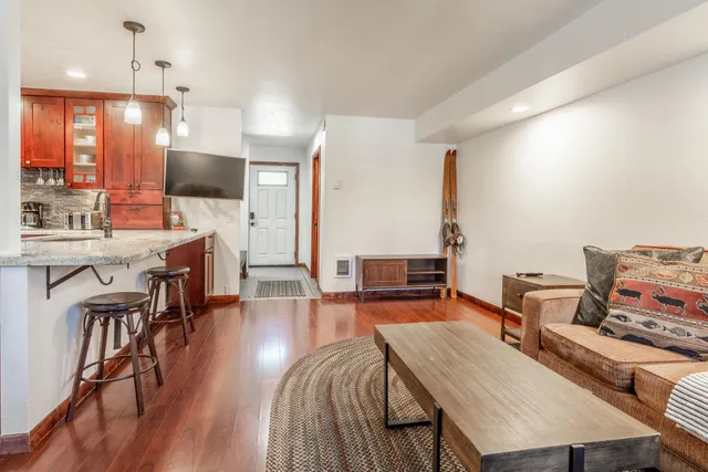 a living room with furniture a flat screen tv and kitchen view
