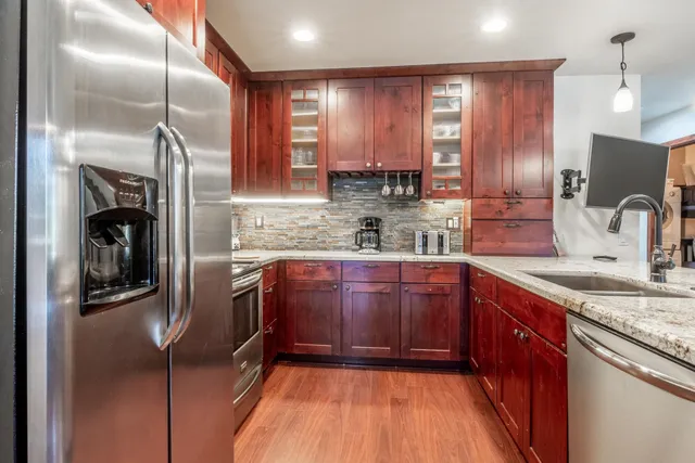 a kitchen with stainless steel appliances granite countertop a sink stove and refrigerator