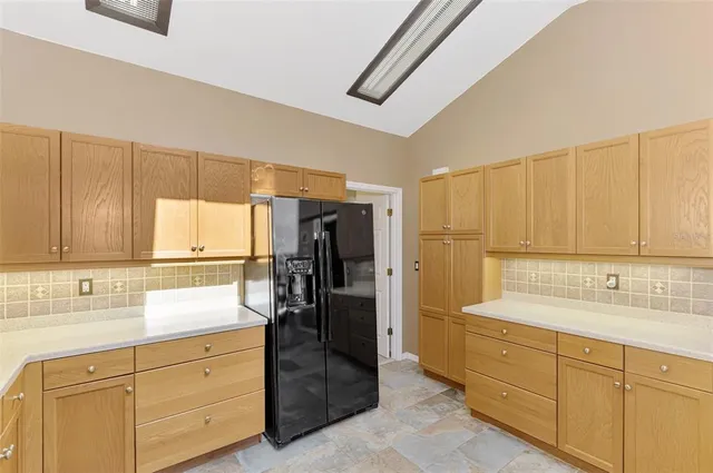 a kitchen with a refrigerator sink and cabinets