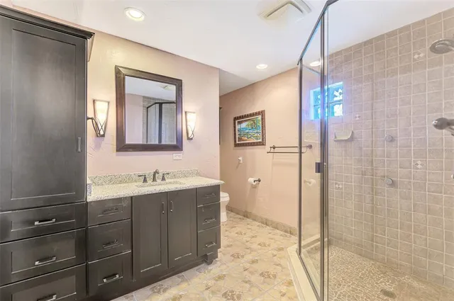 a bathroom with a double vanity sink toilet and shower