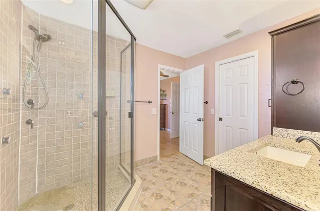 a bathroom with a granite countertop sink and shower