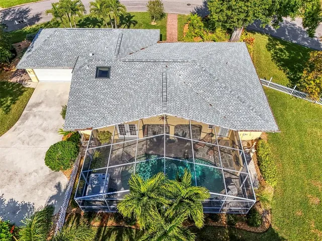 an aerial view of a house with a yard and large trees