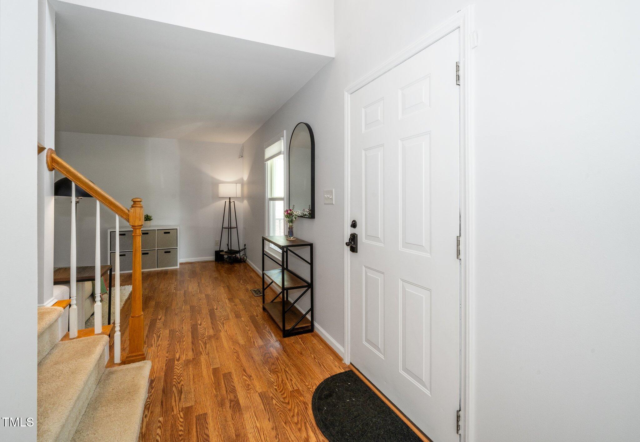 8009 Tobin Place Raleigh, NC 27612 - Photo 4 of 29 a view of a bedroom with wooden floor and a bathroom