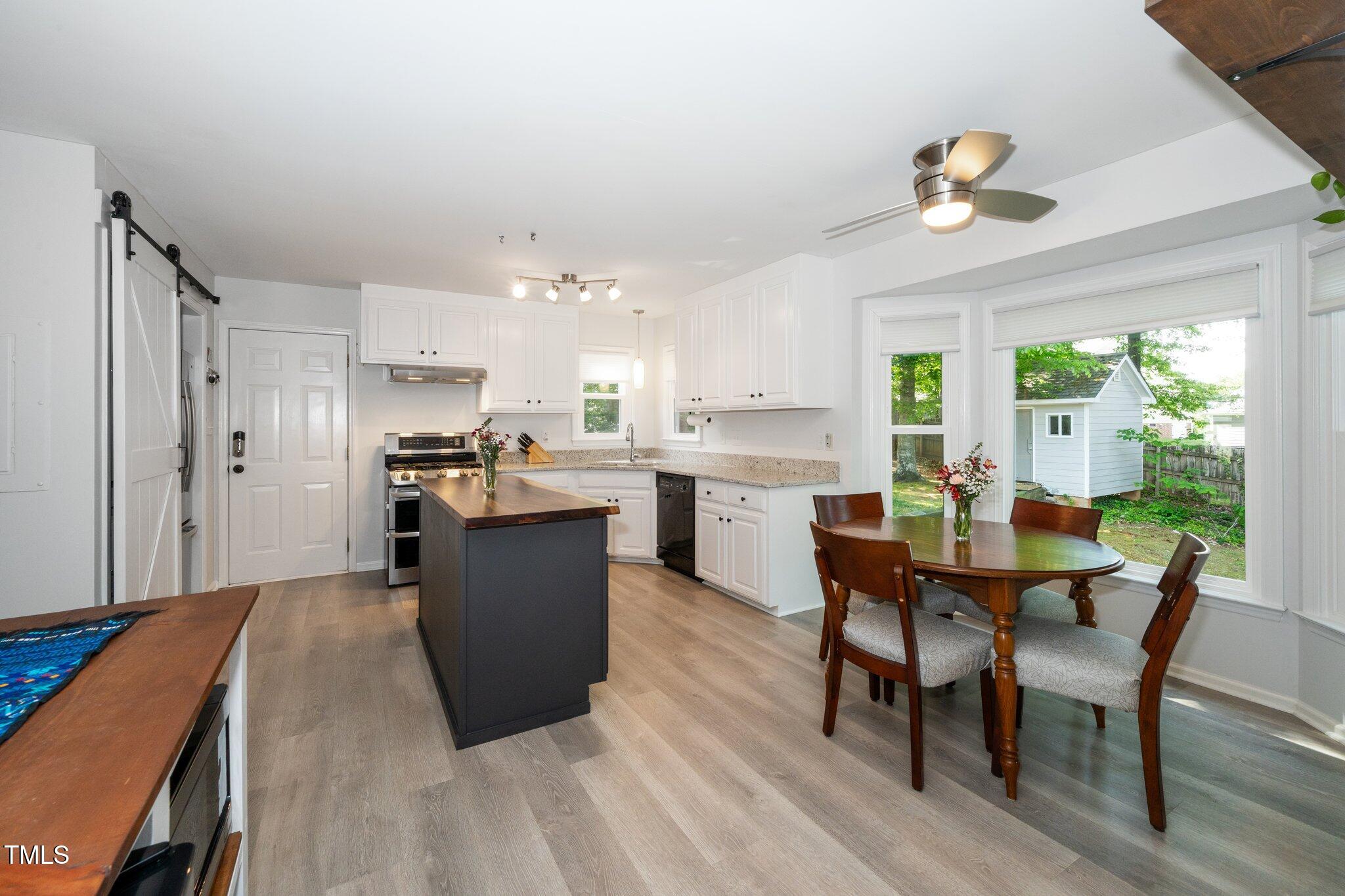 8009 Tobin Place Raleigh, NC 27612 - Photo 8 of 29 a kitchen with stainless steel appliances kitchen island granite countertop a table chairs and a refrigerator