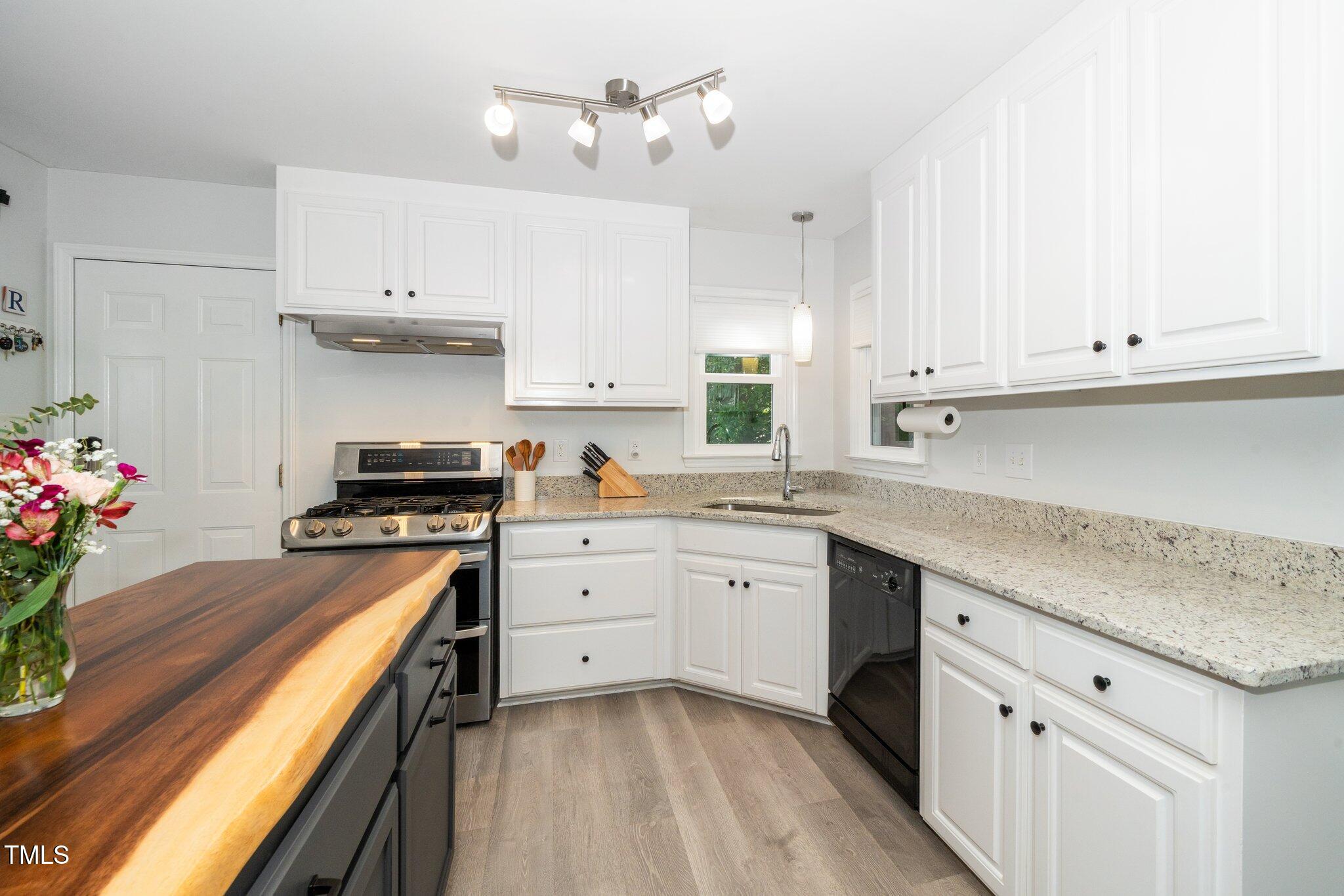 8009 Tobin Place Raleigh, NC 27612 - Photo 10 of 29 a kitchen with granite countertop white cabinets and white appliances