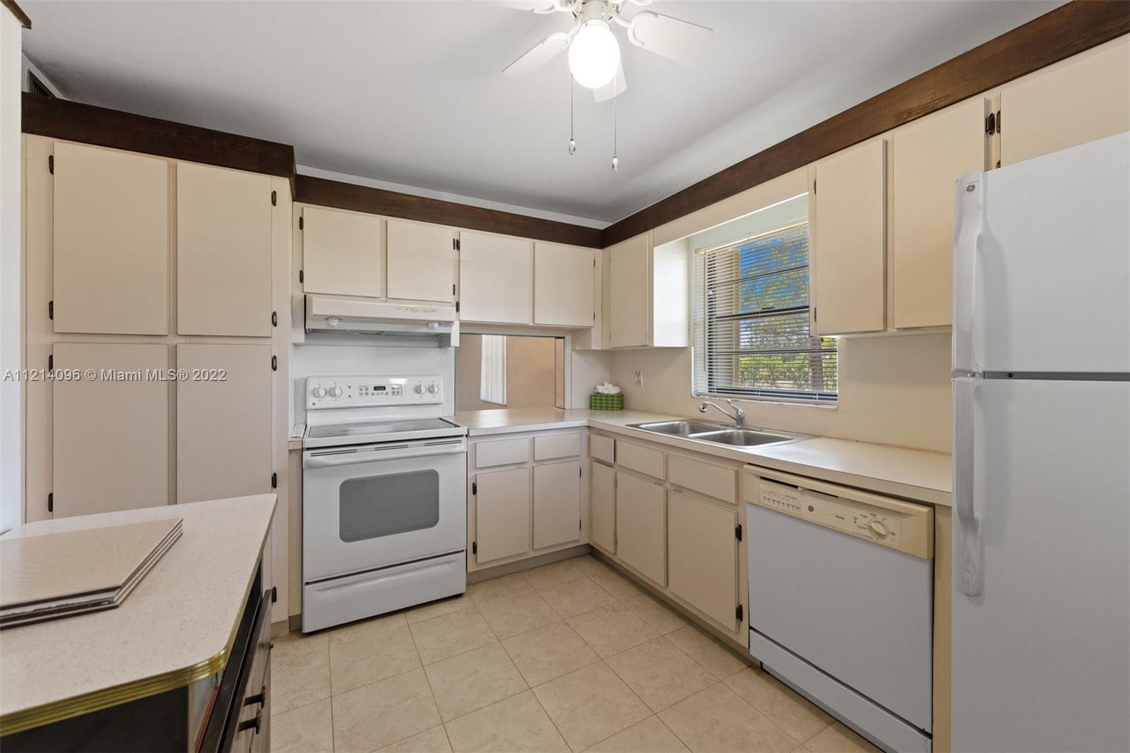 275 Gate Road, Unit 119 Hollywood, FL 33024 - Photo 8 of 32 a kitchen with cabinets appliances a sink and a window