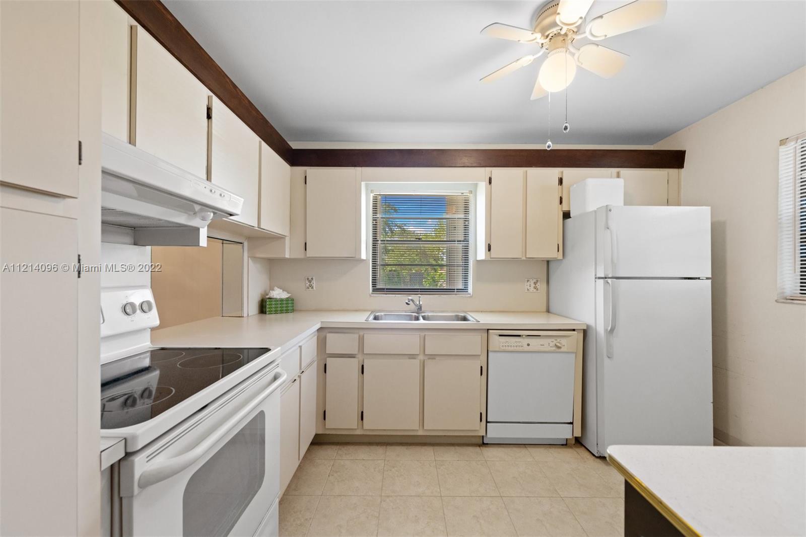 275 Gate Road, Unit 119 Hollywood, FL 33024 - Photo 9 of 32 a kitchen with a sink a refrigerator and cabinets