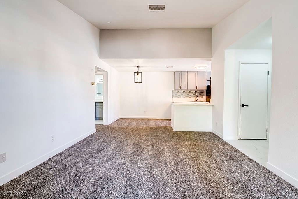 5121 South Lindell Road, Unit 206 Las Vegas, NV 89118 - Photo 8 of 34 Unfurnished living room with carpet floors and baseboards