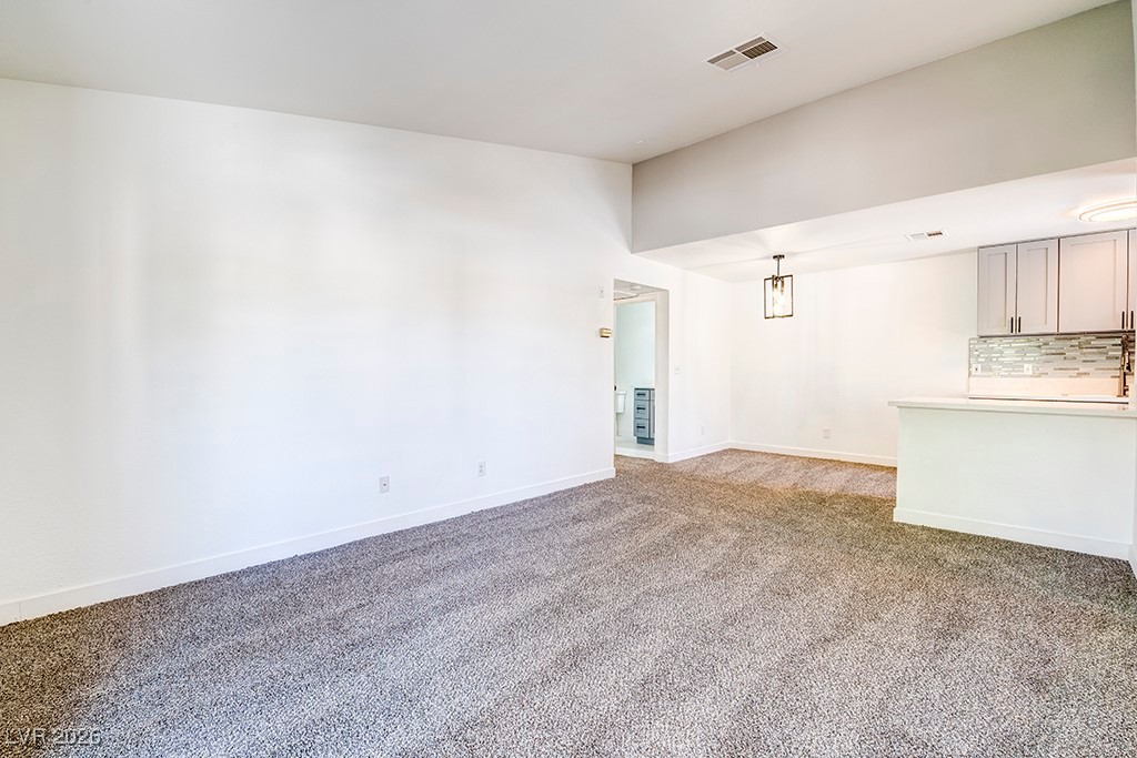 5121 South Lindell Road, Unit 206 Las Vegas, NV 89118 - Photo 10 of 34 Unfurnished living room featuring carpet flooring and baseboards