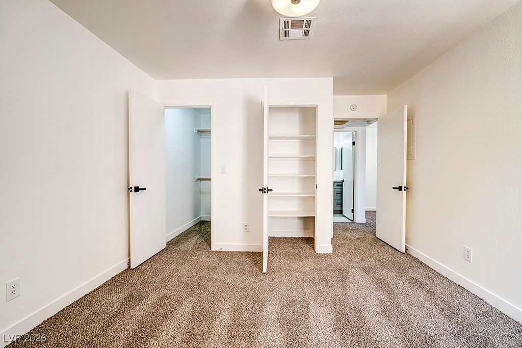 5121 South Lindell Road, Unit 206 Las Vegas, NV 89118 - Photo 15 of 34 Unfurnished bedroom featuring carpet floors and two closets