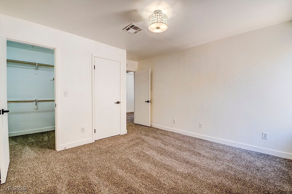5121 South Lindell Road, Unit 206 Las Vegas, NV 89118 - Photo 16 of 34 Unfurnished bedroom with a walk in closet and carpet flooring