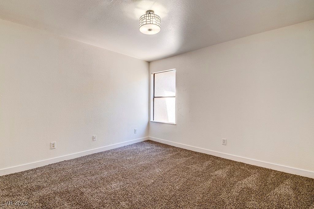 5121 South Lindell Road, Unit 206 Las Vegas, NV 89118 - Photo 18 of 34 Empty room with dark carpet and a textured ceiling
