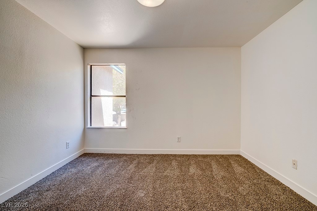 5121 South Lindell Road, Unit 206 Las Vegas, NV 89118 - Photo 19 of 34 Empty room with dark colored carpet and a textured wall