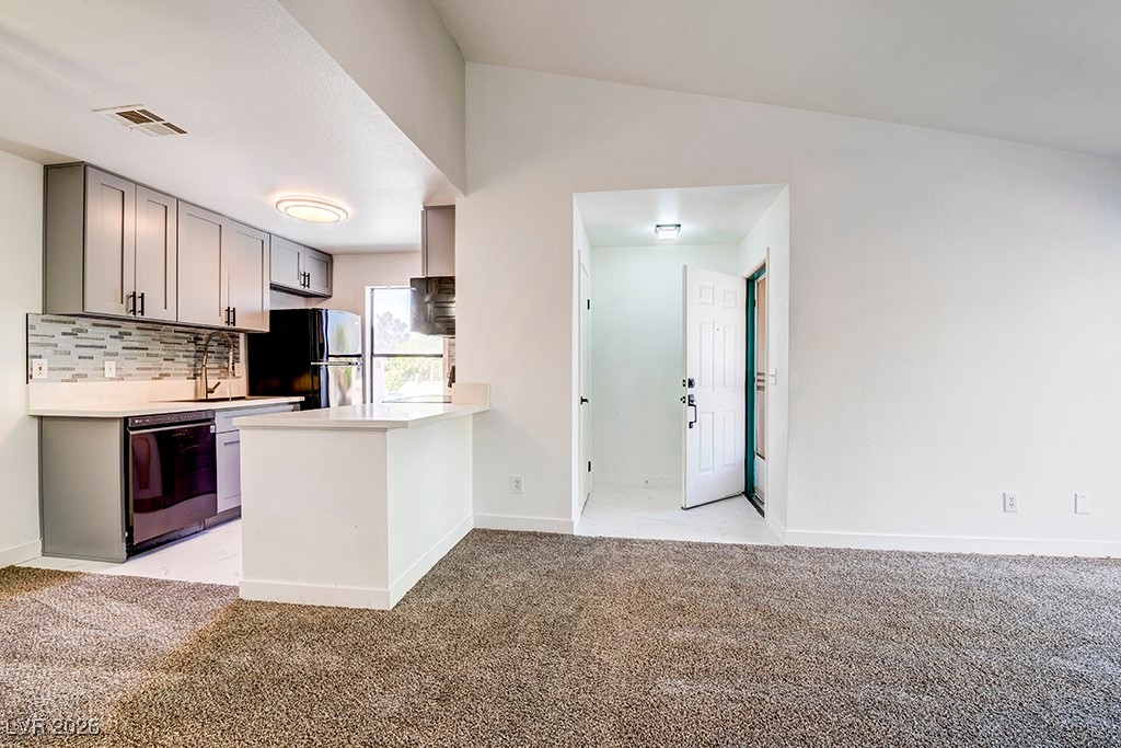 5121 South Lindell Road, Unit 206 Las Vegas, NV 89118 - Photo 34 of 34 Kitchen with gray cabinets, tasteful backsplash, light colored carpet, black appliances, and open floor plan