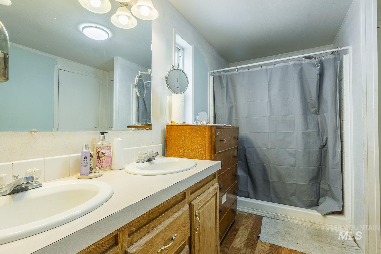 10 Reseda Ridge Circle Garden Valley, ID 83622 - Photo 19 of 28 Bathroom featuring double vanity, a shower with curtain, and wood finished floors