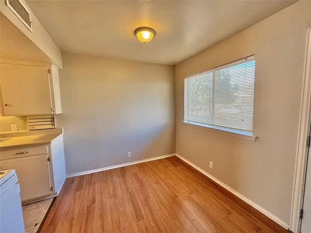 a view of a room with wooden floor and cabinet