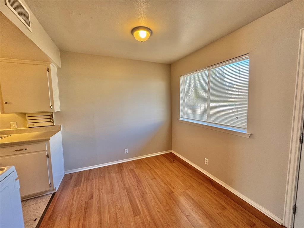 1005 West Hickory Street, Unit W9 Denton, TX 76201 - Photo 2 of 5 a view of a room with wooden floor and cabinet