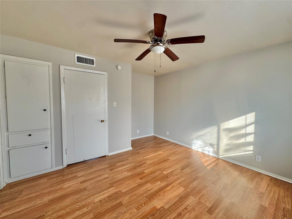 1005 West Hickory Street, Unit W9 Denton, TX 76201 - Photo 4 of 5 a view of empty room with wooden floor and ceiling fan