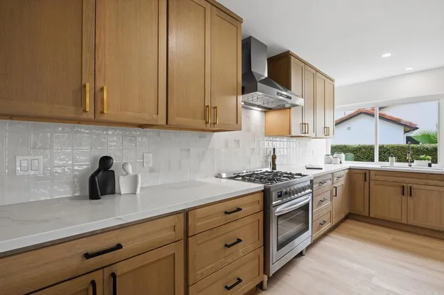 a kitchen with kitchen island granite countertop a sink a stove and a refrigerator