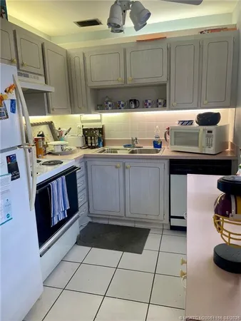 a kitchen with granite countertop a stove a sink and cabinets
