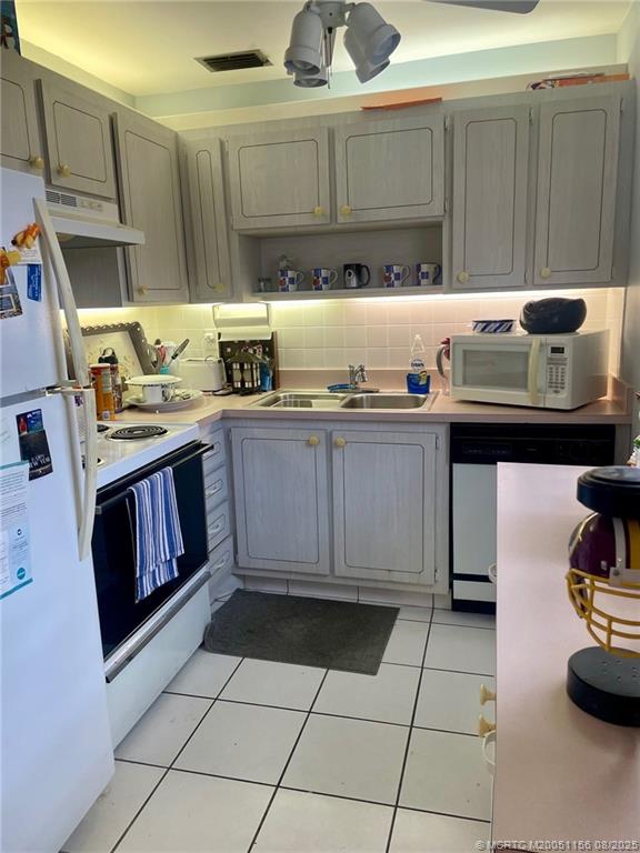 2600 Southeast Ocean Boulevard, Unit A12 Stuart, FL 34996 - Photo 6 of 17 a kitchen with granite countertop a stove a sink and cabinets
