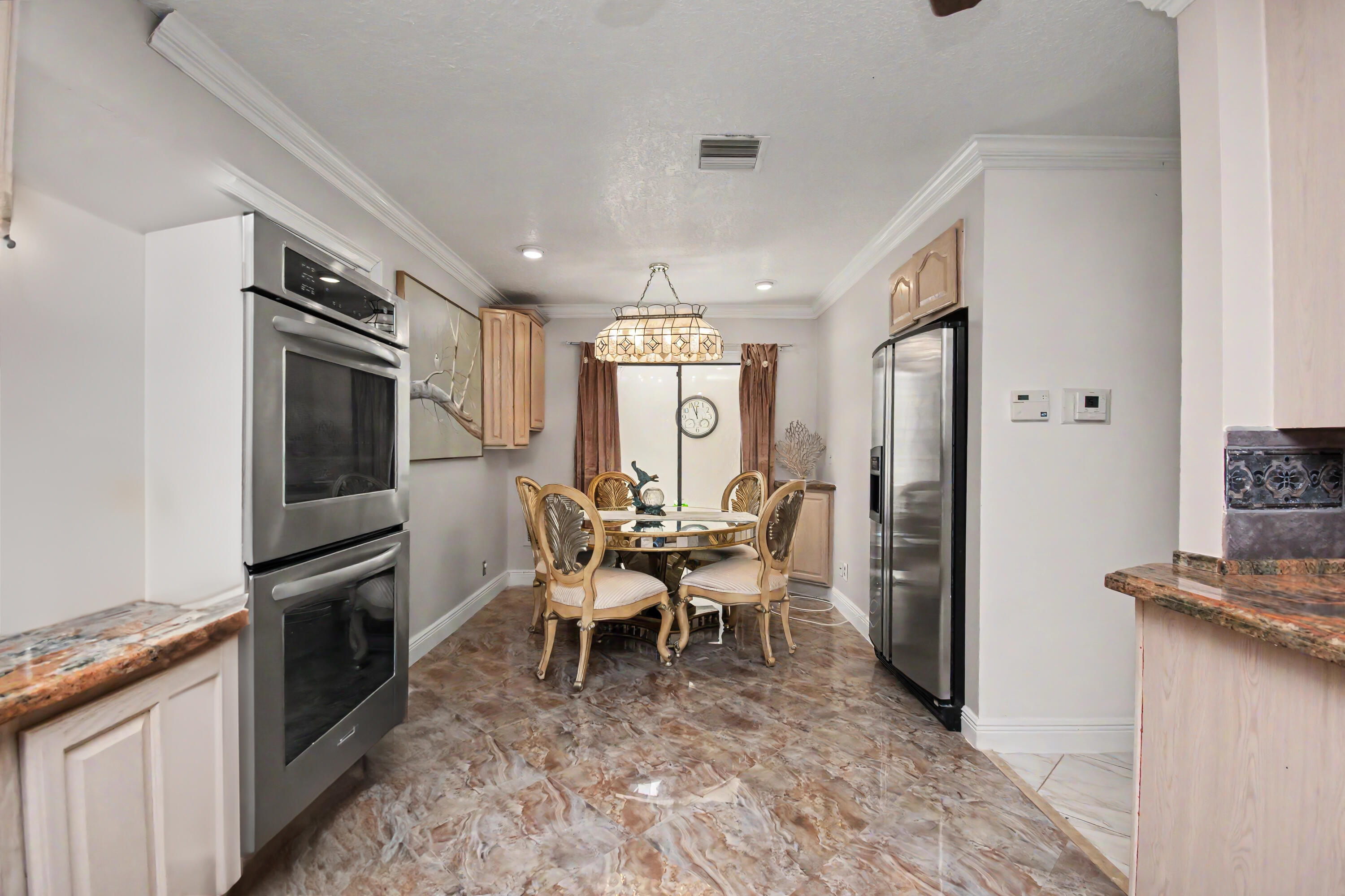 9708 Erica Court Boca Raton, FL 33496 - Photo 25 of 54 a dining room with furniture and a kitchen
