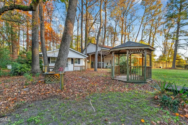 a view of a yard with table and chairs potted plants