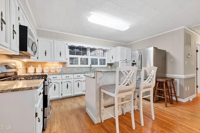 a kitchen with granite countertop a white stove top oven sink and cabinets