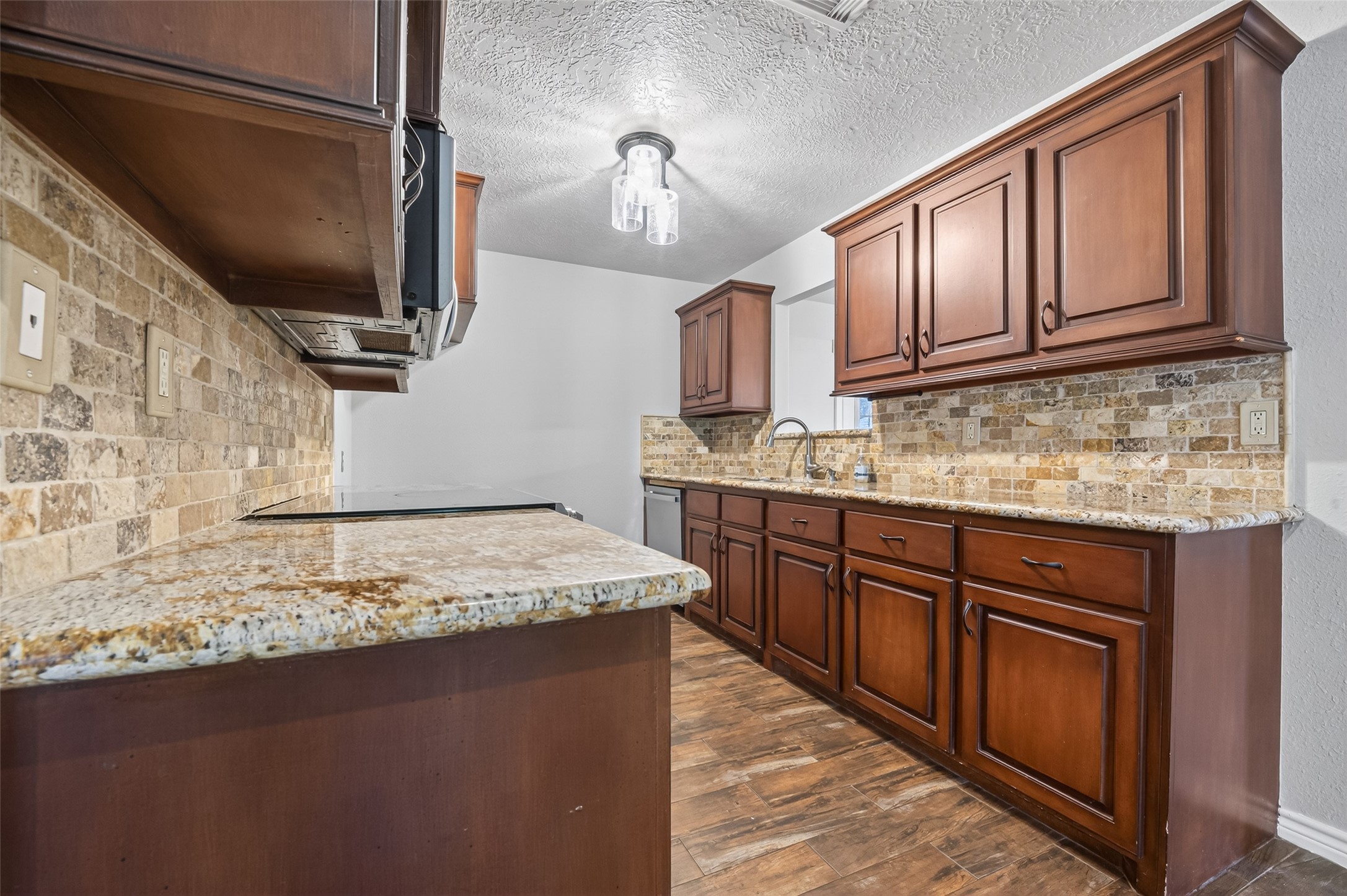 1007 West Cedar River Road Conroe, TX 77316 - Photo 11 of 48 This kitchen is well-lit with a modern fixture, offering a warm and inviting atmosphere.