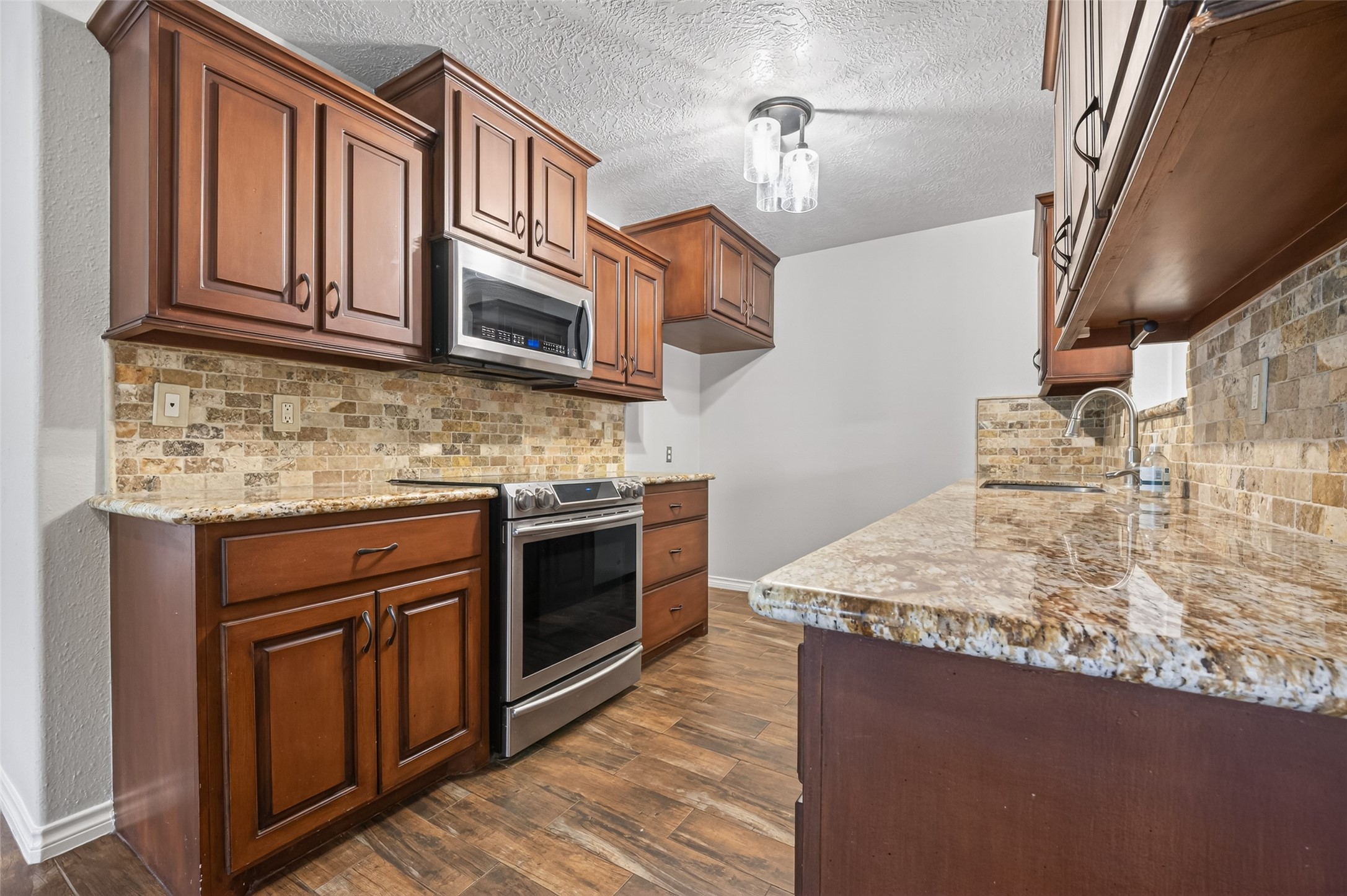 1007 West Cedar River Road Conroe, TX 77316 - Photo 12 of 48 a kitchen with stainless steel appliances granite countertop a sink stove and cabinets