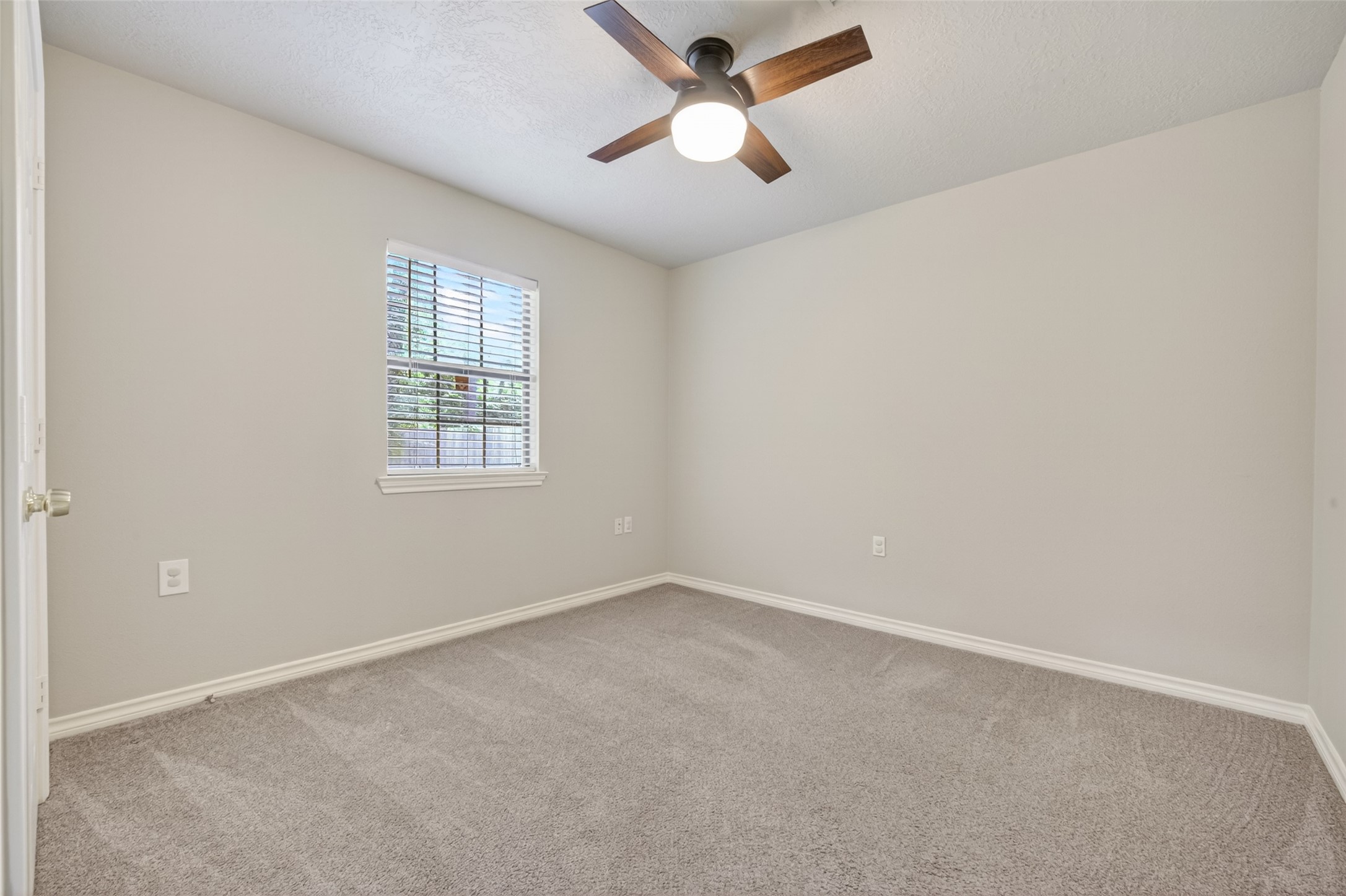 1007 West Cedar River Road Conroe, TX 77316 - Photo 24 of 48 This is a cozy bedroom with freshly painted walls and carpet flooring. It features a ceiling fan with a light and a window that provides natural light. #3 secondary bedroom