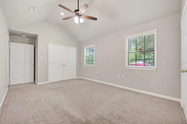 an empty room with windows and fan