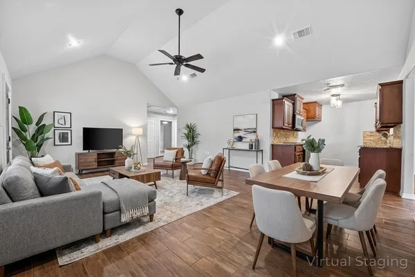 a living room with furniture kitchen view and a flat screen tv