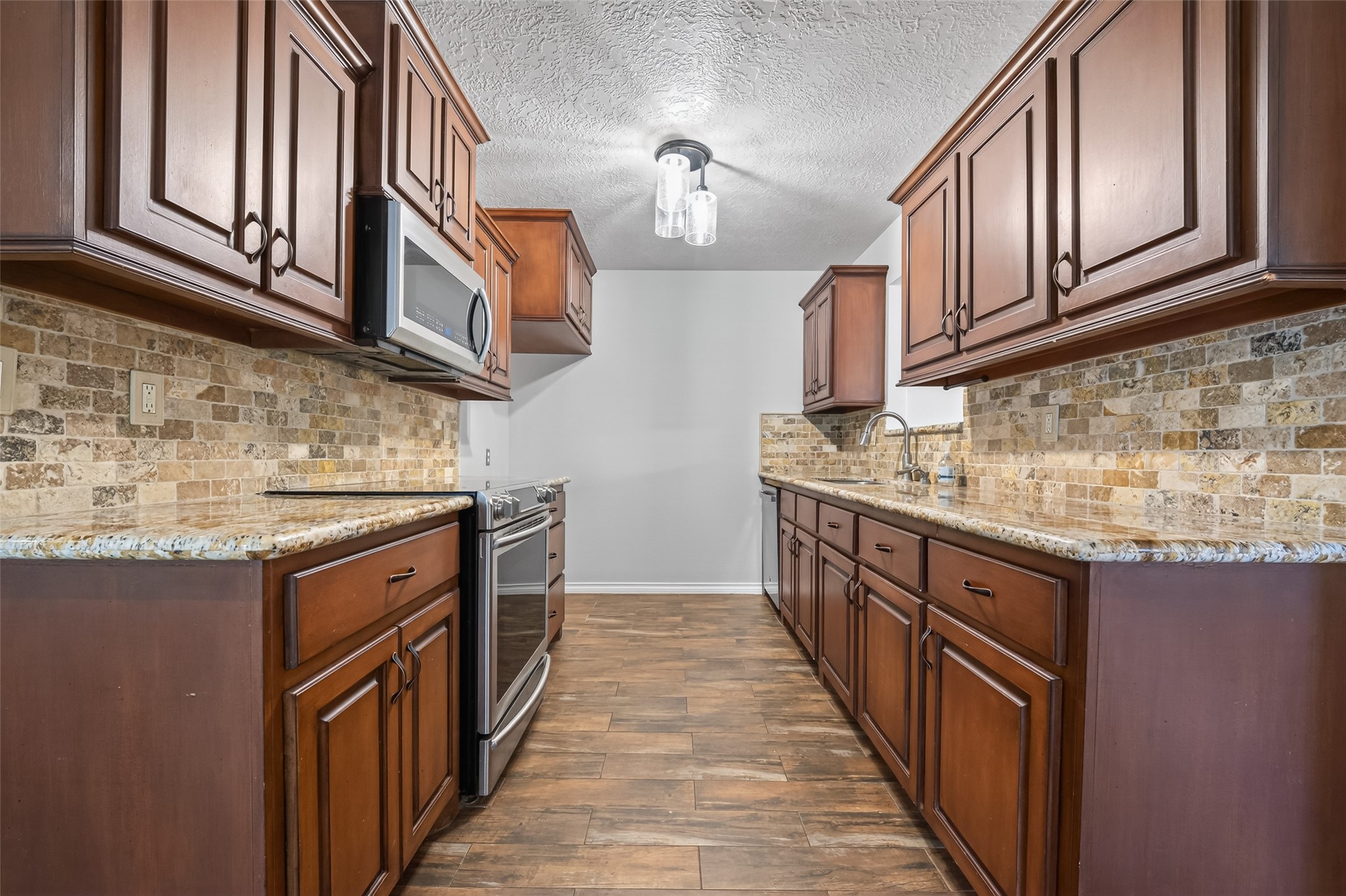1007 West Cedar River Road Conroe, TX 77316 - Photo 10 of 48 a kitchen with stainless steel appliances granite countertop a sink and dishwasher a stove top oven with wooden floor