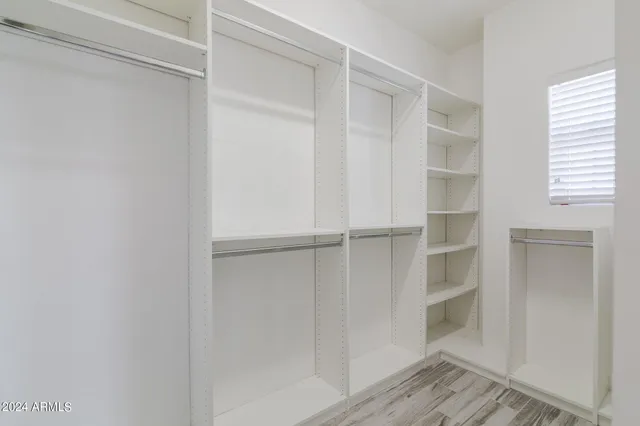 a view of walk in closet with empty racks