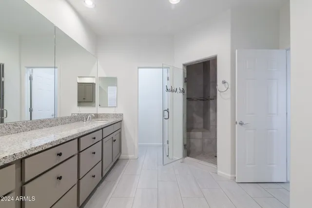 a bathroom with a granite countertop sink mirror and shower