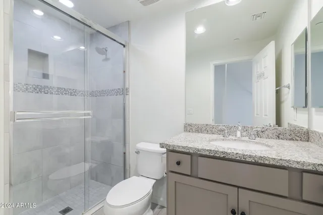 a bathroom with a granite countertop sink toilet and shower