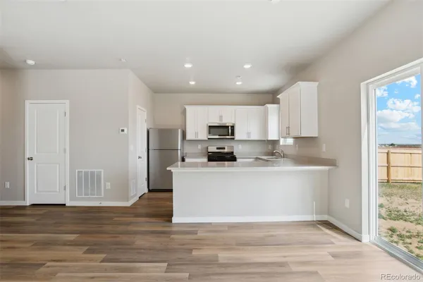 a kitchen with a refrigerator a stove a microwave and cabinets