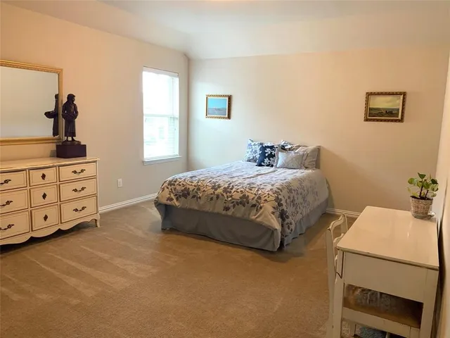 a bedroom with a bed and a dresser in it