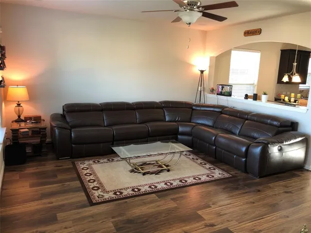 a living room with furniture and a wooden floor
