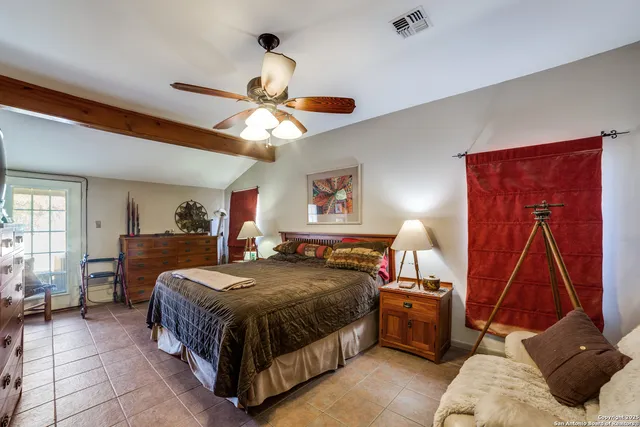 a bedroom with a bed a large window and furniture