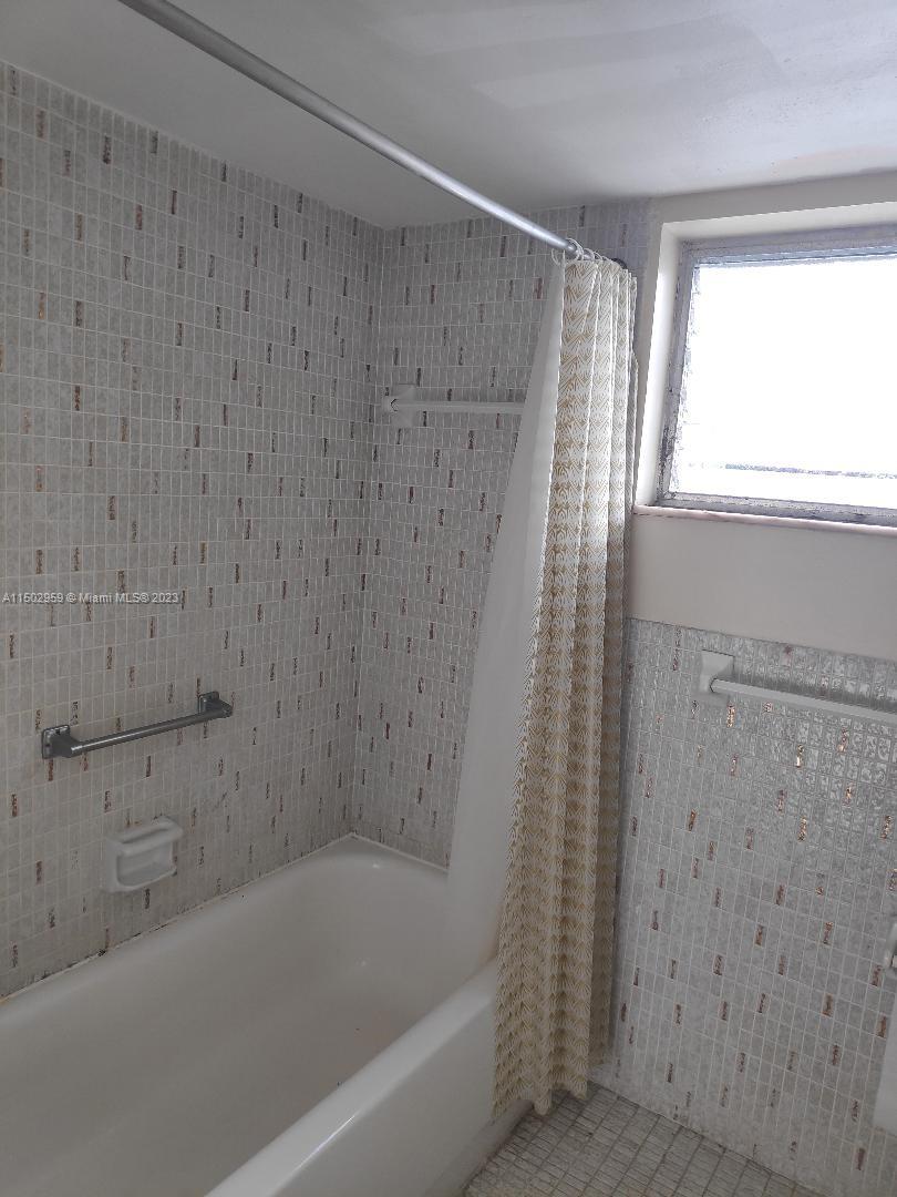 1680 Northeast 191st Street, Unit 2182 Miami, FL 33179 - Photo 4 of 8 a bathroom with a bathtub