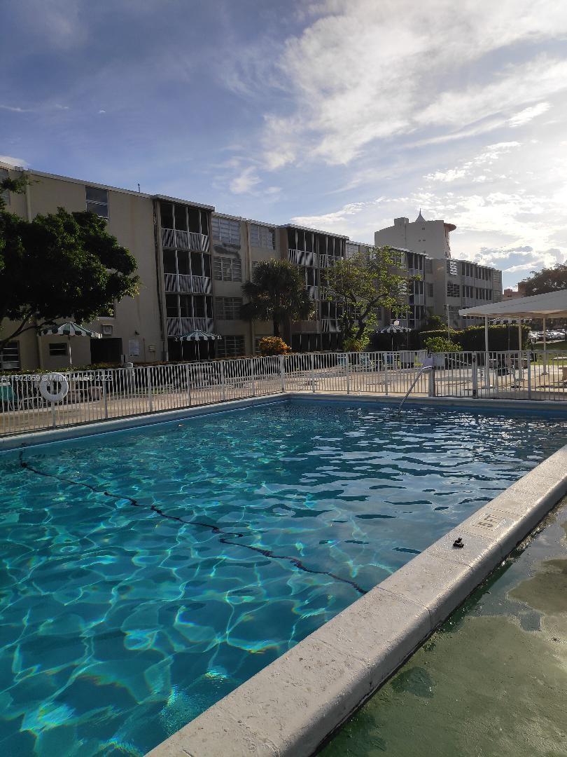 1680 Northeast 191st Street, Unit 2182 Miami, FL 33179 - Photo 6 of 8 a view of a swimming pool with outdoor seating and plants
