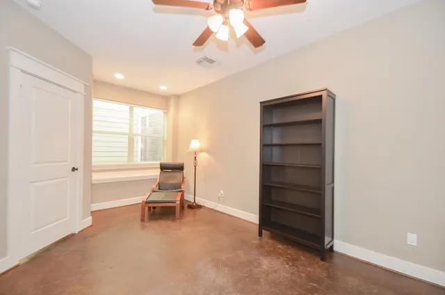 a living room with a furniture and a ceiling fan