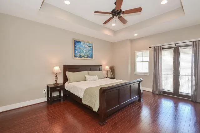 a view of a bedroom with wooden floor and ceiling fan