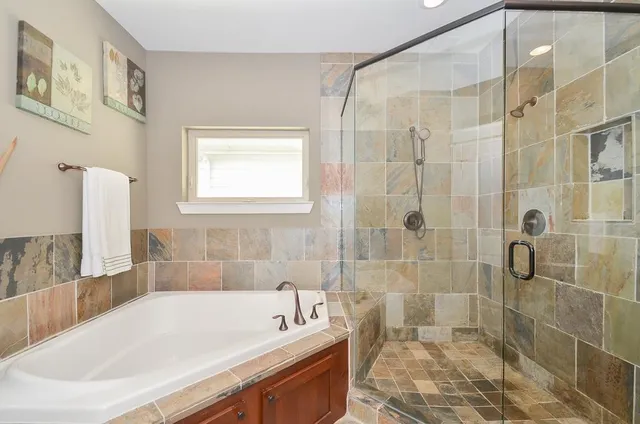 a bath tub sitting next to a white sink and a shower