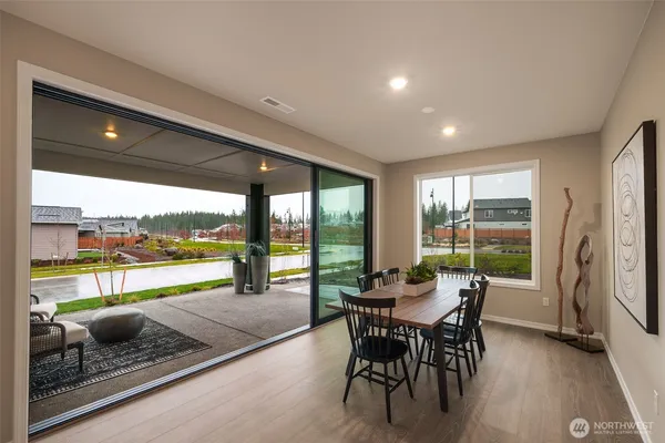 a dining room with furniture and a floor to ceiling window